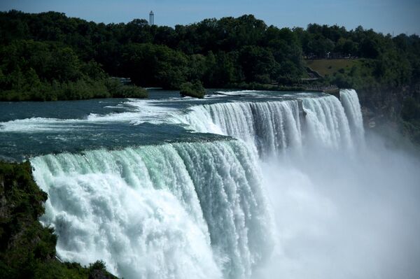 Ниагарский водопад - каскад водопадов на границе Америки и Канады. Водопад можно назвать самым эффектным естественным разломом земной коры. Река Ниагара, соединяющая озера Эри и Онтарио, падает с высоты 50-метрового обрыва шириной более километра - Sputnik Латвия
