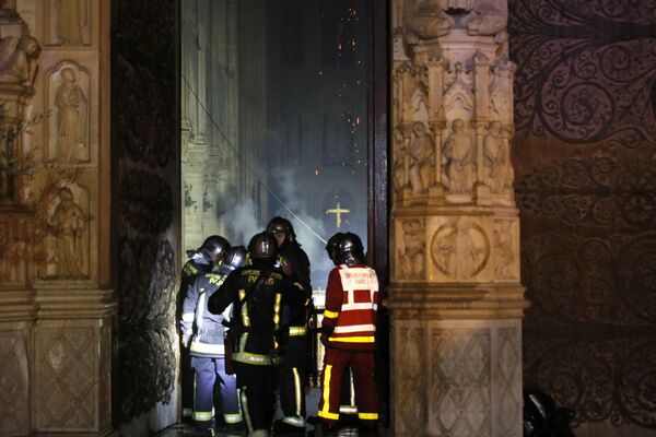 Пожарные во время тушения пожара в соборе Парижской Богоматери - Sputnik Латвия