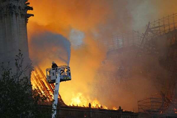 Пожарные во время тушения пожара в соборе Парижской Богоматери - Sputnik Латвия
