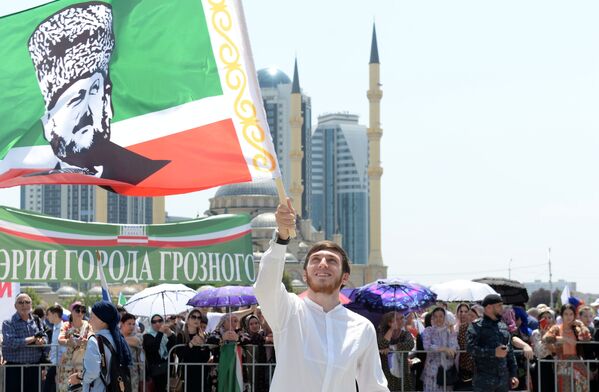 Участник праздничного митинга, посвященного Дню России, на площади перед мечетью Сердце Чечни в Грозном - Sputnik Латвия