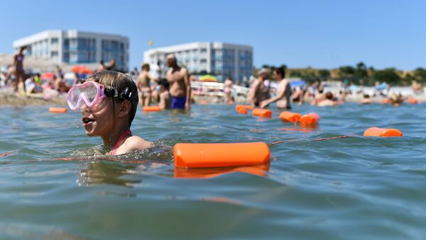 Отдыхающие купаются в Черном море возле пляжа Солдатский в Севастополе в Крыму - Sputnik Latvija