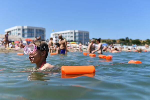Отдыхающие купаются в Черном море возле пляжа Солдатский в Севастополе в Крыму - Sputnik Латвия