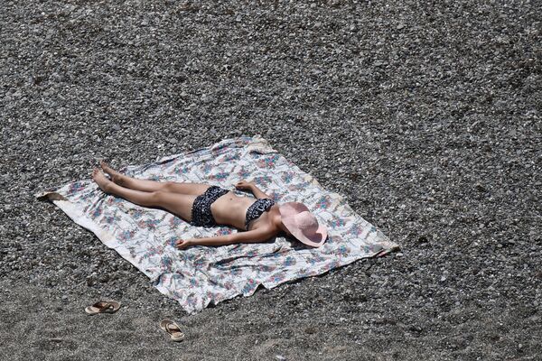 Девушка загорает на пляже возле мыса Меганом в Крыму - Sputnik Латвия