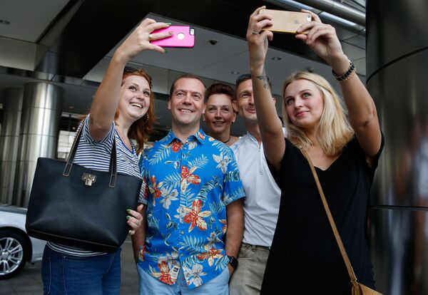 Премьер-министр России Дмитрий Медведев во время фотографирования с российскими и украинскими туристами в Куала-Лумпуре  - Sputnik Латвия