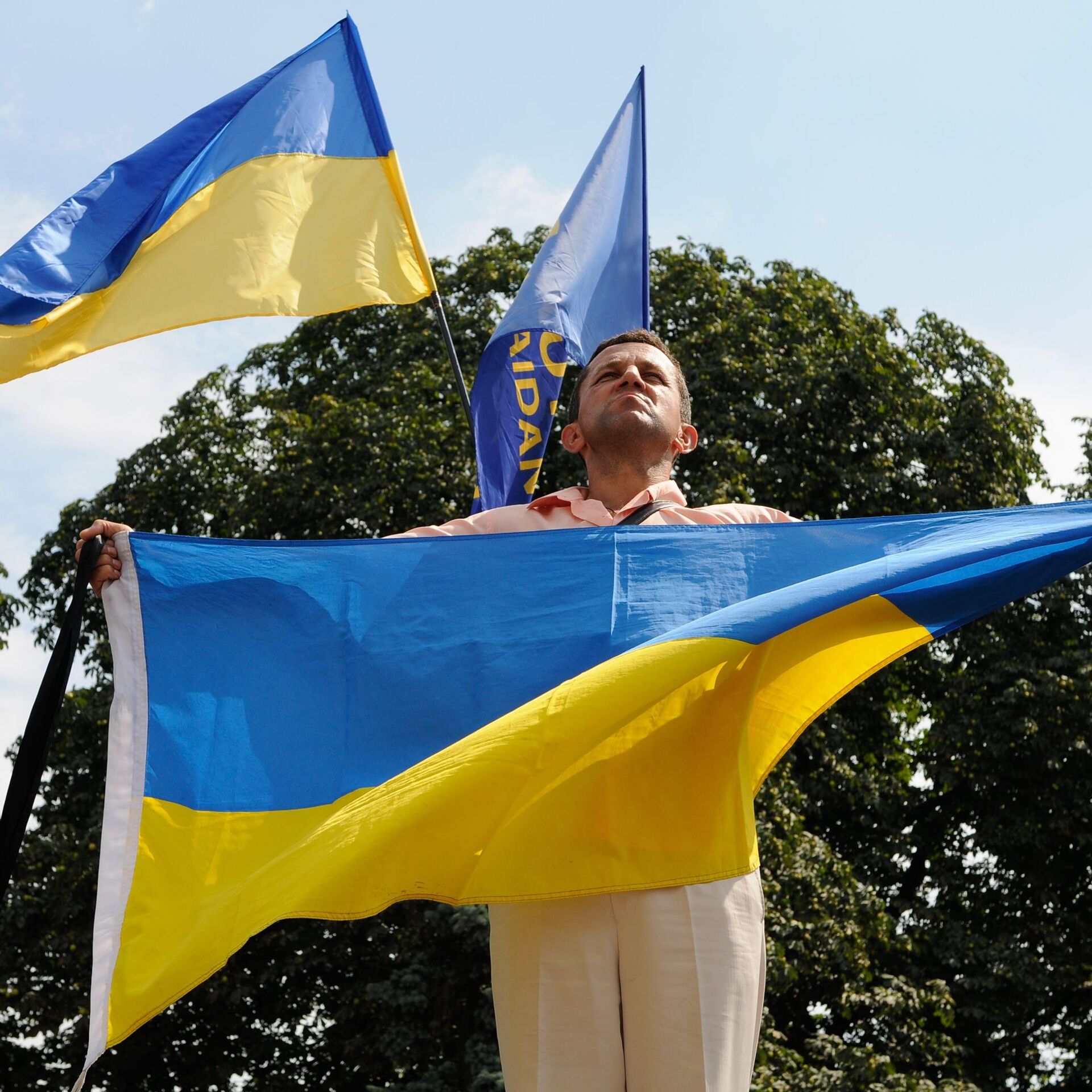 Биография украинца. Украинцы с флагом. Парень с флагом Украины. Украинцы в Греции. Украинский флаг в руках.