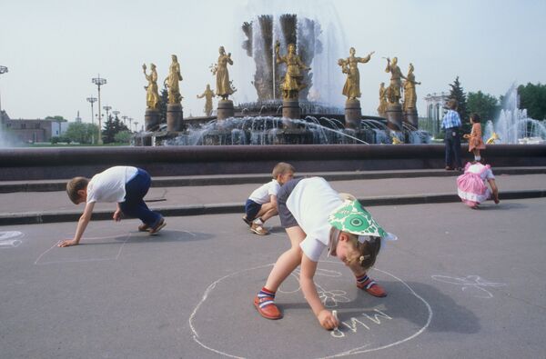 Дети рисуют мелом на асфальте у фонтана Дружба народов в Москве. 1984 - Sputnik Латвия