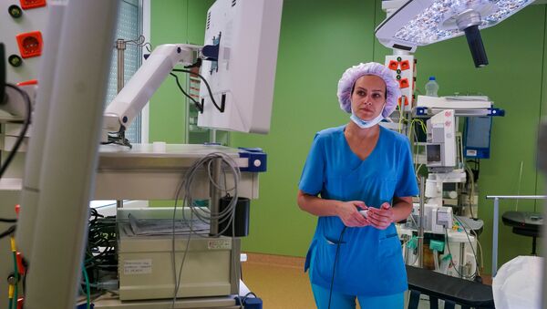 Операционная сестра готовит оборудование к операции - Sputnik Latvija