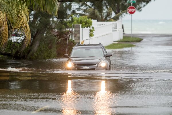 Автомобиль проезжает по затопленной в результате урагана Дориан улице в Нассау, Багамы - Sputnik Латвия