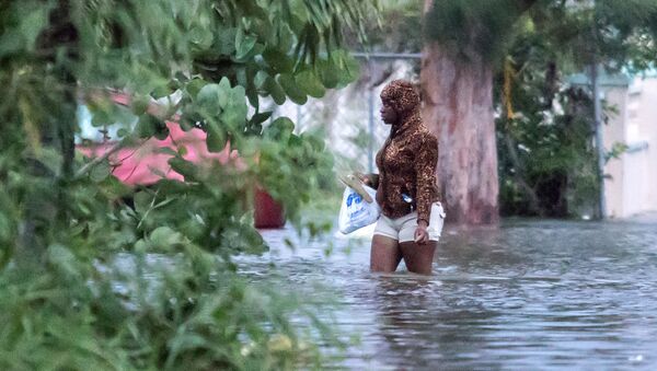 Женщина идет по затопленной в результате урагана Дориан улице в Нассау, Багамы - Sputnik Латвия