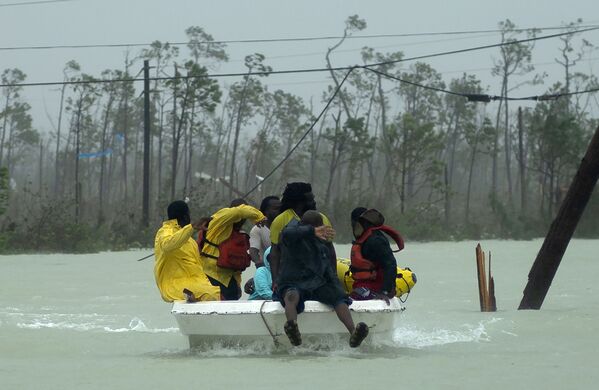 Добровольцы на лодке спасают семью от вызванного ураганом Дориан наводнения во Фрипорте - Sputnik Латвия