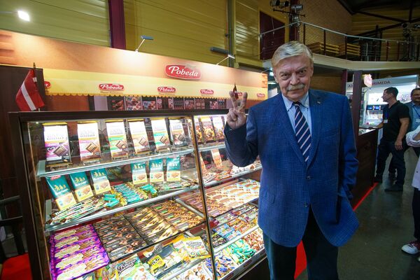 Посол России в Латвии Евгений Лукьянов на стенде производителя шоколада Победа - Sputnik Латвия