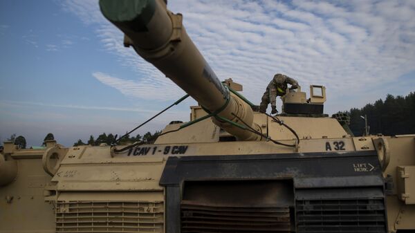 Американский военнослужащий готовит танк Abrams к разгрузке на железнодорожной станции в Литве - Sputnik Латвия