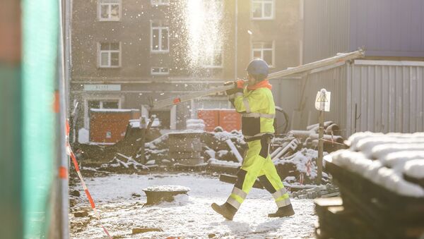 Первый снег в Риге. Рабочий на стройплощадке - Sputnik Латвия