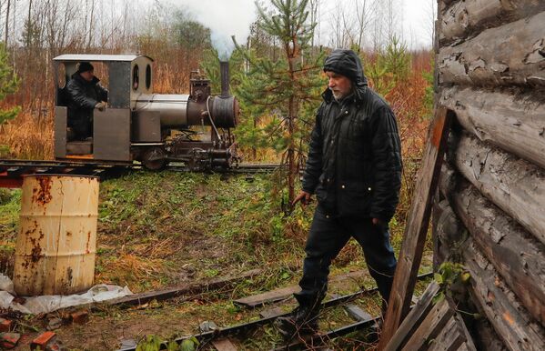 Инженер-энтузиаст Павел Чилин проходит мимо своего самодельного паровоза, который проезжает по железной дороге в поселке Ульяновка Ленинградской области Инженер-энтузиаст Павел Чилин проходит мимо своего самодельного паровоза, который проезжает по железной дороге в поселке Ульяновка Ленинградской области - Sputnik Латвия
