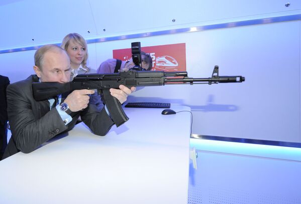 Председатель правительства РФ, избранный президент России Владимир Путин с помощью макета автомата АК-74 стреляет в мишень в электронном тире - Sputnik Латвия