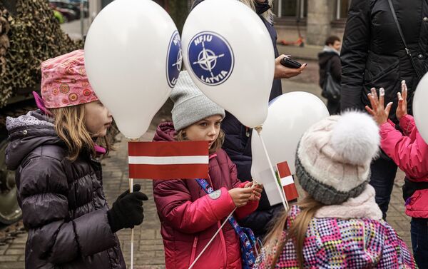 Дети с шариками Подразделения по интеграции сил НАТО (NFIU) и латвийскими флажками в День Лачплесиса - Sputnik Латвия