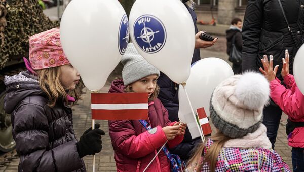 Bērni ar NATO integrācijas spēku vienības (NFIU) baloniem un Latvijas karogiem Lāčplēša dienā - Sputnik Latvija
