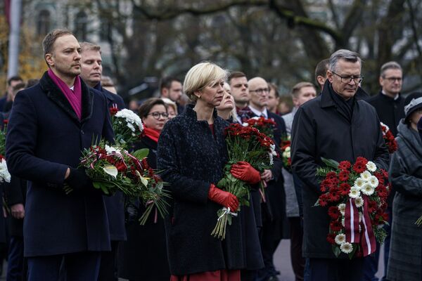Министр внутренних дел Сандис Гиргенс и экс-министр здравоохранения Анда Чакша возлагают цветы к памятнику Свободы - Sputnik Латвия