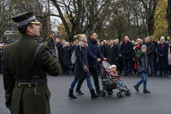 Семья с детьми проходит к памятнику Свободы, чтобы возложить цветы Семья с детьми проходит к памятнику Свободы, чтобы возложить цветы - Sputnik Латвия