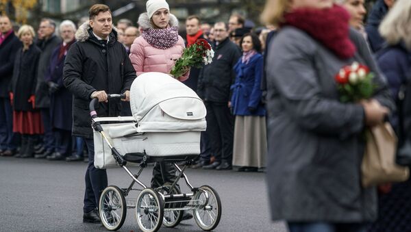 Семья с ребенком проходит к памятнику Свободы, чтобы возложить цветы - Sputnik Латвия