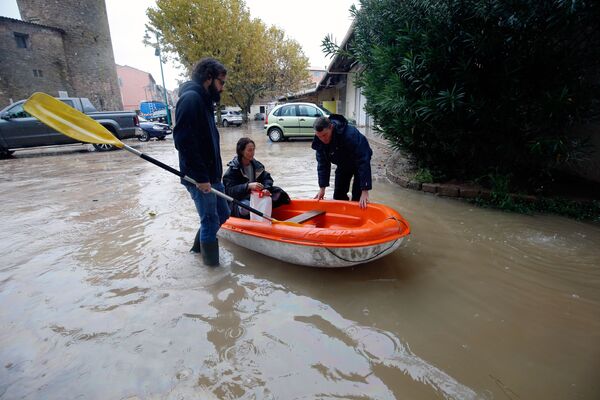Люди в надувной лодке на одной из улиц Лемю на юго-востоке Франции после наводнения - Sputnik Латвия