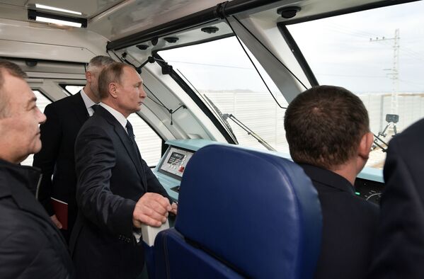 Президент России Владимир Путин в кабине машиниста рельсового автобуса, который отправляется в первый рейс по железной дороге Крымского моста - Sputnik Латвия