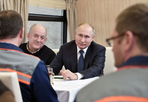 Президент России Владимир Путин с рабочими-мостовиками во время поездки на рельсовом автобусе, который отправился по железной дороге Крымского моста - Sputnik Латвия