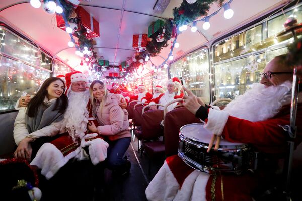 Музыканты в костюмах Санта-Клауса в автобусе в Санкт-Петербурге. Музыканты в костюмах Санта-Клауса в автобусе в Санкт-Петербурге. - Sputnik Латвия