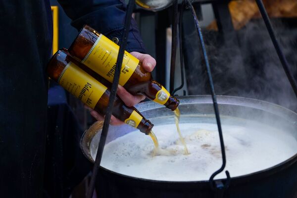 Пиво разогревали в котле, прямо на костре, превращая его в согревающий напиток. Четвертый фестиваль уличной еды Street Food Festival в Риге. - Sputnik Латвия