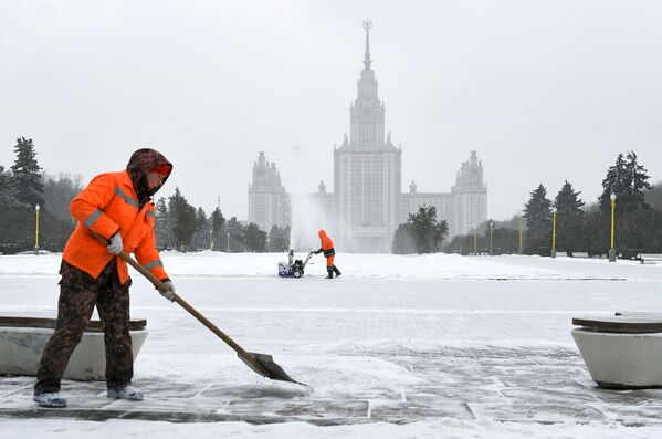 Сотрудники коммунальной службы во время уборки снега возле здания МГУ на Воробьевых горах в Москве - Sputnik Латвия