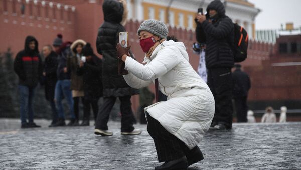 Иностранные туристы в защитных масках на Красной площади в Москве - Sputnik Латвия