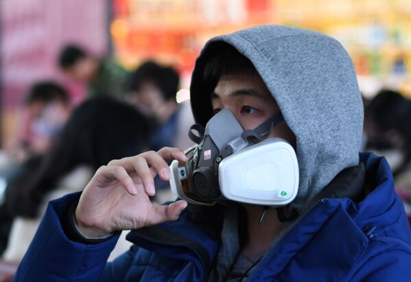 Пассажир в дыхательной маске на вокзале Пекина, Китай  - Sputnik Латвия
