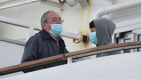 Пассажиры в медицинских масках на борту круизного лайнера Diamond Princes, помещенного в карантин у японского порта Йокогама - Sputnik Latvija