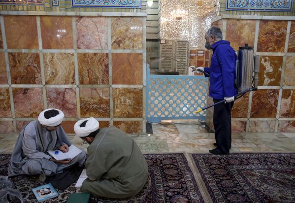 Работник санитарной службы дезинфицирует мавзолей Фатимы Масуме в иранском городе Кум - Sputnik Латвия