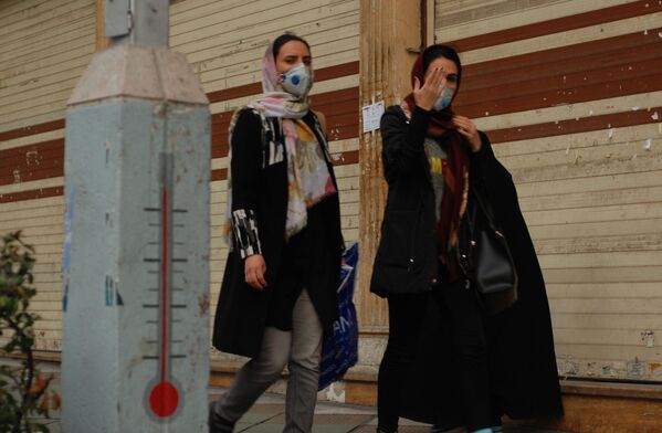 Жители Тегерана идут по одной из центральных улиц в медицинских масках - Sputnik Латвия