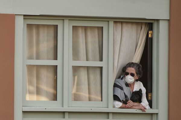 Женщина смотрит из окна Costa Adeje Palace hotel на Тенерифе - Sputnik Латвия