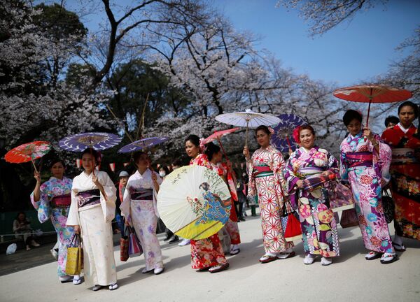 Иностранцы в кимоно на фоне цветущей вишни в Токио  - Sputnik Латвия