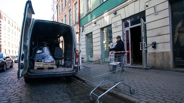 Грузчики выносят вещи из закрытого магазина в Старой Риге - Sputnik Латвия