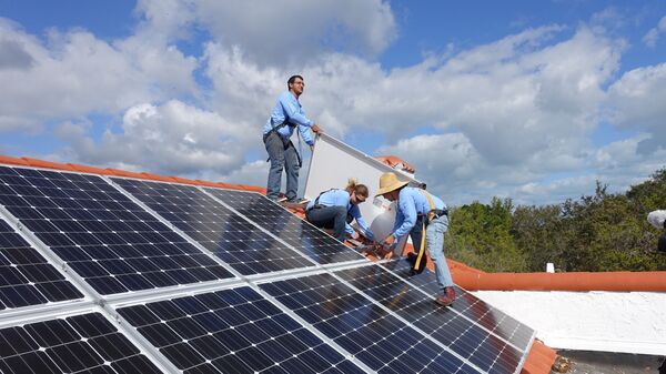 Рабочие устанавливают солнечные батареи на крыше дома в Пальметто Бэй, штат Флорида - Sputnik Латвия