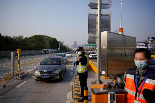 Полицейский на платной скоростной автомагистрали на выезд из Уханя, Китай Полицейский на платной скоростной автомагистрали на выезд из Уханя, Китай - Sputnik Латвия