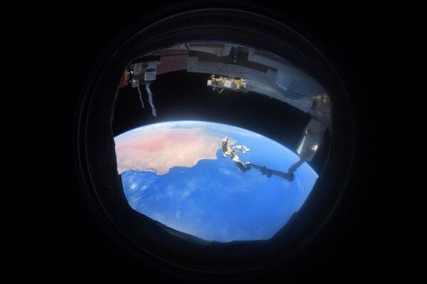 Снимок Земли через иллюминатор, сделанный на МКС космонавтом Антоном Шкаплеровым - Sputnik Латвия