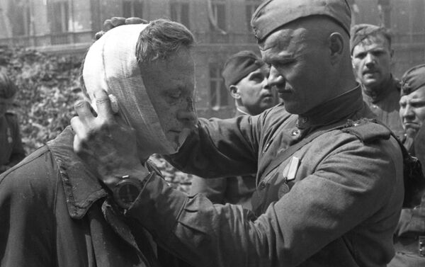 Padomju karavīrs sniedz medicīnisko palīdzību vietējam iedzīvotājam Padomju karavīrs sniedz medicīnisko palīdzību vietējam iedzīvotājam - Sputnik Latvija