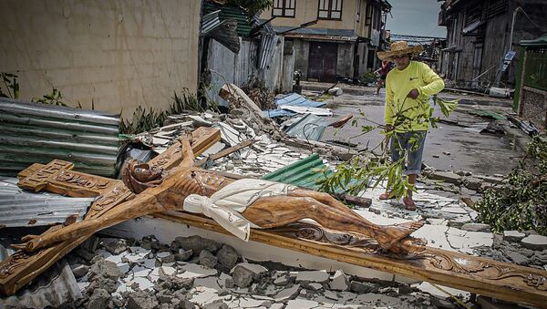 Местный житель на улице после тайфуна Вонгфонг, обрушившегося на центральную часть Филиппин - Sputnik Латвия
