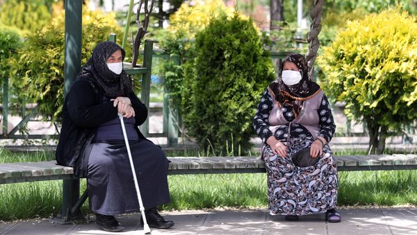 Пожилые женщины в медицинских масках на скамейке в одном из парков Анкары, Турция - Sputnik Латвия