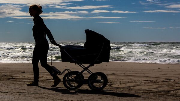 Jaunā māmiņa ar bērnu ratiņiem jūras krastā - Sputnik Latvija