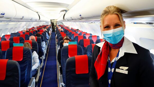 Стюардесса в медицинской маске в салоне самолета в международном аэропорту Брюсселя - Sputnik Латвия
