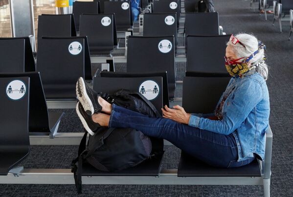 Пассажирка в защитной маске в терминале  международного аэропорта Брюсселя - Sputnik Латвия