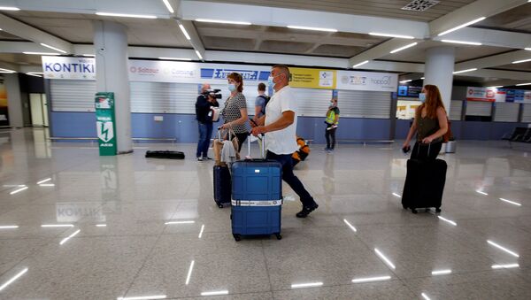 Туристы из Германии в медицинских масках в аэропорту Пальма-де-Майорка в Испании - Sputnik Latvija