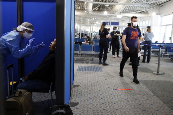 Прибывшего из Катара пассажира тестируют на коронавирус в международном аэропорту Элефтериос Венизелос в Афинах - Sputnik Латвия