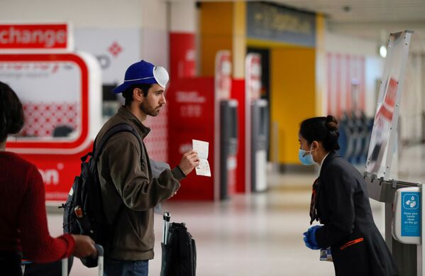 Пассажир предъявляет свой паспорт сотруднику в аэропорту Гатвик, Великобритания - Sputnik Латвия